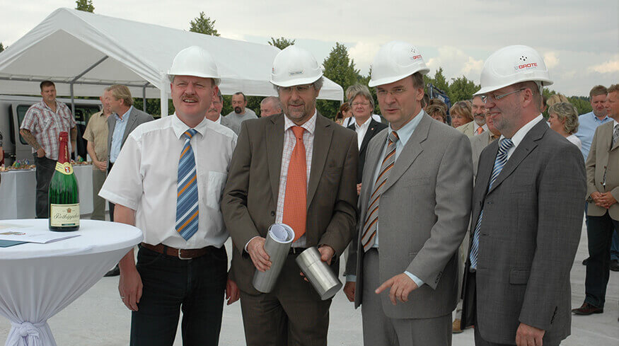 Vier Personen bei der Einweihungsfeier des neuen Gebäudes der Elektromotoren und Gerätebau Barleben GmbH