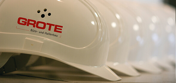 Weiße Baustellen-Helme mit dem Logo von GROTE.