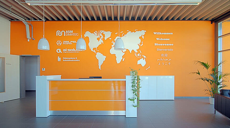 Eingangsbereich mit Empfangstresen im neuen Büro- und Betriebsgebäude der ASM Dimatec Deutschland GmbH.